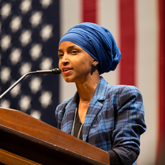Rep. Ilhan Omar at podium in front of American flag