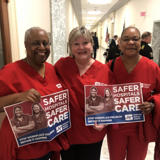 Nurses in DC government hallway with signs "Safer hospitals safer care. Stop workplace violence before it happens"