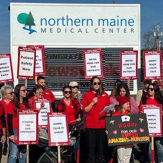 Nurses rally outside of hospital holding signs "We're here for our patients"