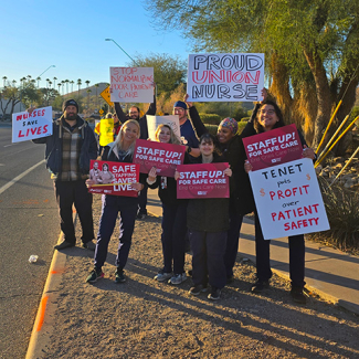 Nurses outside holding signs "Staff up for safe patient care"