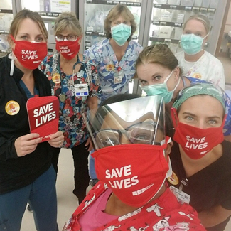 TCMC nurses holding signs and wearing masks "Save Lives"