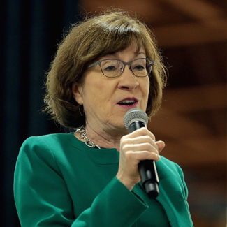 Susan Collins holding microphone