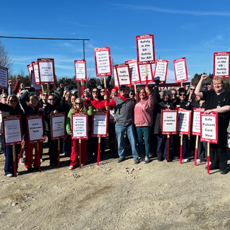 Large group of Machias nurses and techs on the strike line with lots of picket signs about staffing and retention