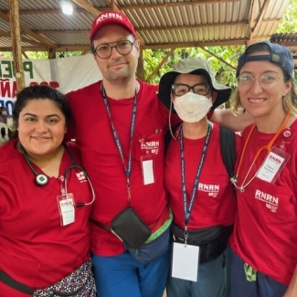 Four nurses in red scrubs in rural area of Guatemala 