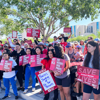 MountainView nurses holding signs like "Save Lives: Safe Staffing Now", "Hey HCA put patients over profits"
