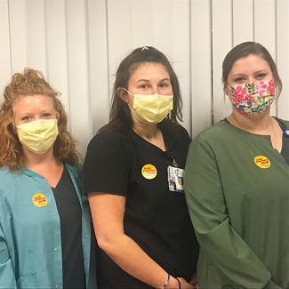 Three nurses inside hospital standing side-by-side