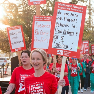 Nurses on picket line holding signs supporting patient safety and need