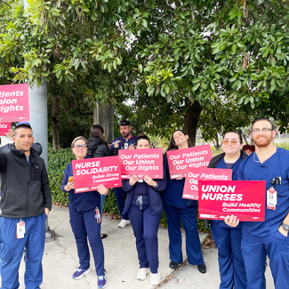 Nurses holding signs: "Our patients, our union, our rights" "Nurse solidarity builds strong communities" "Union nurses build healthy communities"