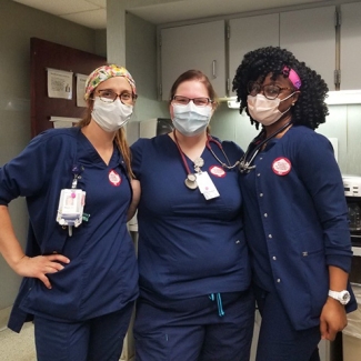 Three masked nurses inside hospital