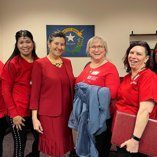 Three nurses standing, smiling with Nevada State Sen. Rochelle Nguyen