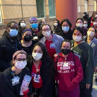 Large group of nurses and care givers outside hospital