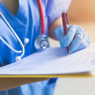 Nurse with clipboard signing document