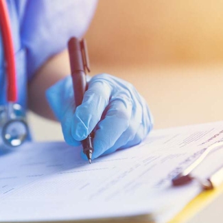 Nurse signing paperwork on clipboard