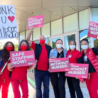 Kaiser nurses holding signs "Safe staffing now!" and "There's no Kaiser without nurses!"