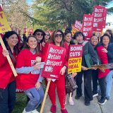 Nurses on picket line hold signs "Recruit, Retain, Respect RNs"