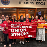 Group of nurses inside, smiling, holding banner "Ventura County Nurses: Union Strong"