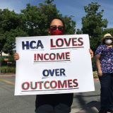 Nurses holds sign "HCA Loves Income Over Outcomes"