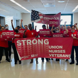 Large group of nurses inside hospital, holdig banner "Strong Union, Nurses, Veterans" and signs "Staff Up for Safe Care"