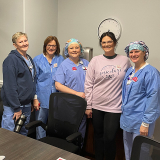 5 nurses inside hospital smiling