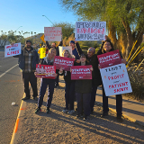 Nurses outside holding signs "Staff up for safe patient care"