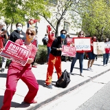 Nurses holding signs along street "Protect Nurses, Patients, Public Health"