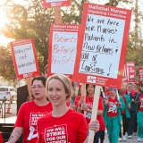 Nurses on picket line holding signs supporting patient safety and need