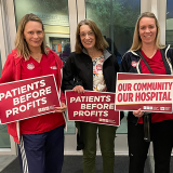 4 nurses from Desert Regional Medical Center holding signs "Patients before profits" and "Our community, our hospital"