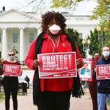 Nurses with signs in front of capitol "Protect Nurses, Patients, Public Health"