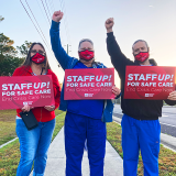 Three Oak Hill RNS holding signs "Staff up for safe care! End crisis care now."
