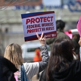 Hand holding sign "Protect Federal Workers, Protect VA Nurses"