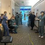 Group on nurses inside hospital hold raised fists