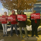 Four nurses outside Research Medical Center holding signs "Union Nurses Build Healthy Communities"