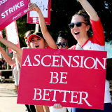 Nurse holding sign "Ascension: Be Better"