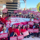 Large group of nurses holding signs "Don't lay off our Kaiser nurses"