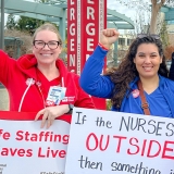 AHLM nurses picket holding signs with fists raised.