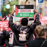 Nurse marching with sign "End Genocide in Gaza"