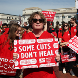 Nurses holding signs "Some Cuts Don't Heal"
