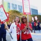 Nurses outside hospital holding signs "Nurses are the true spirit of charity"
