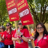 Nurses outside, holding signs "Enloe Nurses United"