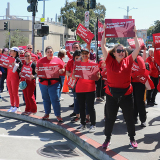 Nurses picketing outside hospital, holding signs "Patients are not algrorithms"