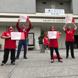 Nurses hold signs "Nurses Essential to Patient Care"