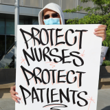 Nurse holds "Protect Nurses" signs