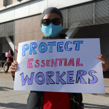 Nurse holds sign "Protect Essential Workers"