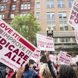National Nurses United union members wave "Medicare-for-all" signs
