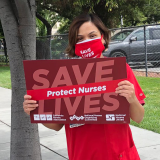 Nurse holds sing "Save Lives"