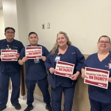 Dignity nurses holding signs that say "Nurses bargain for RN dignity."